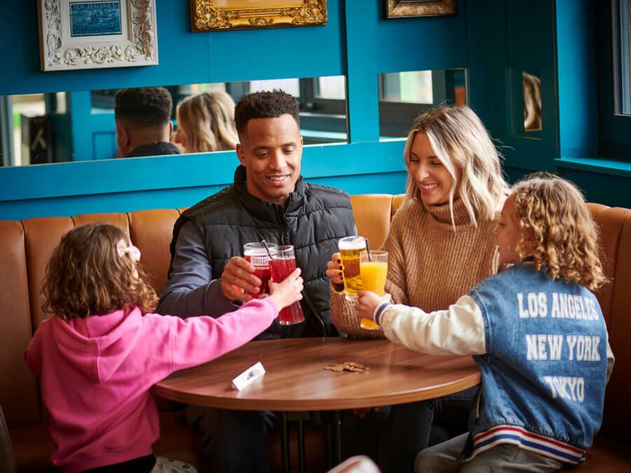 A family of four enjoying a drink in the Explorer's Bar & Coffee Shop at Fantasy Island theme park resort