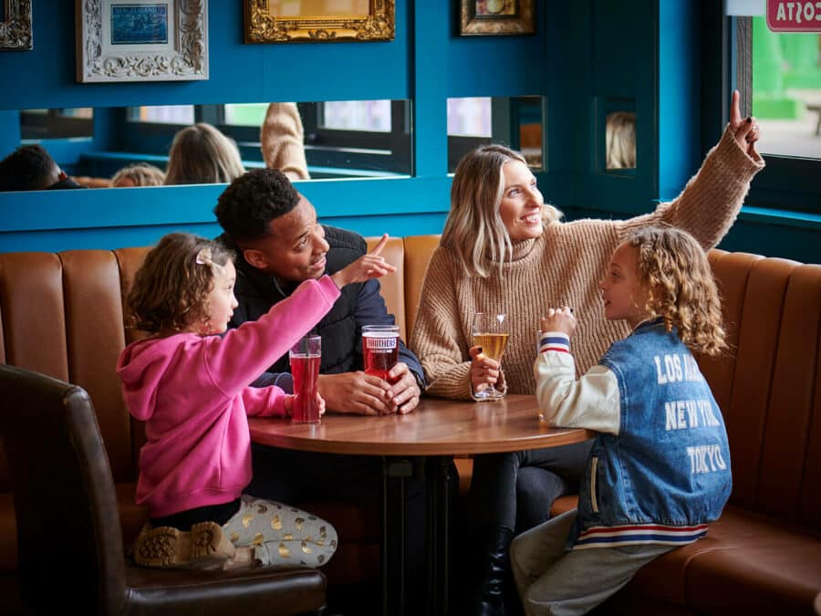 A family of four enjoying a drink in the Explorer's Bar & Coffee Shop at Fantasy Island theme park resort