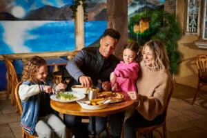 A family of four enjoying a meal in the Explorer's Bar & Coffee Shop at Fantasy Island theme park resort