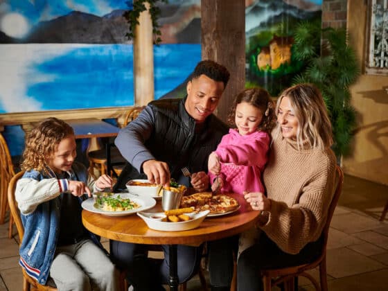 A family of four enjoying a meal in the Explorer's Bar & Coffee Shop at Fantasy Island theme park resort