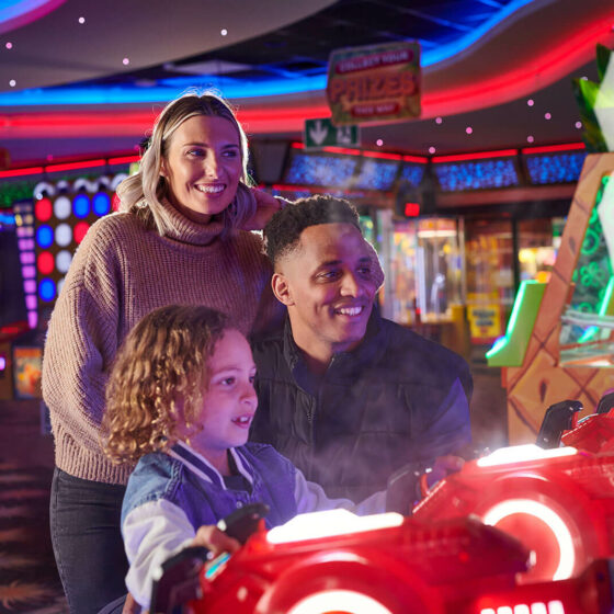 A family of three playing on the games at Fantasy Island Ingoldmells