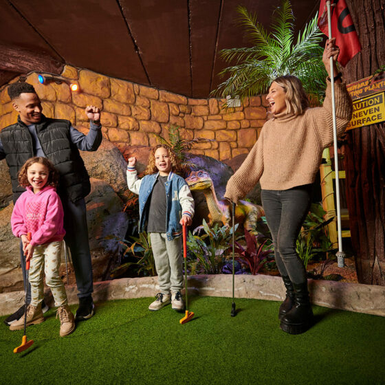 Family of four playing golf at Lava Creek Adventure Golf at Fantasy Island